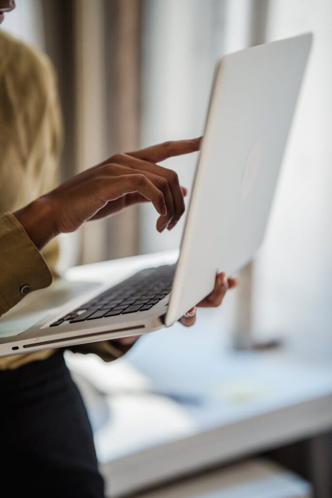 pexels-photo-12899121 A woman uses a laptop indoors, captured in a vertical close-up shot emphasizing technology and workspace.