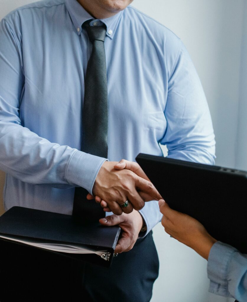 pexels-photo-5668839-5668839 Business handshake between colleagues in a formal office meeting setting.